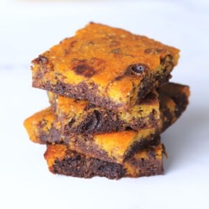 Four healthy pumpkin brownies stacked on top of each other.