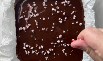 Topping the sugar free peppermint mocha cheesecake with crushed peppermint candy.