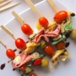 Low carb antipasto skewers on a white platter.