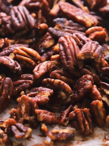 Low carb candied pecans on a parchment lined baking sheet.