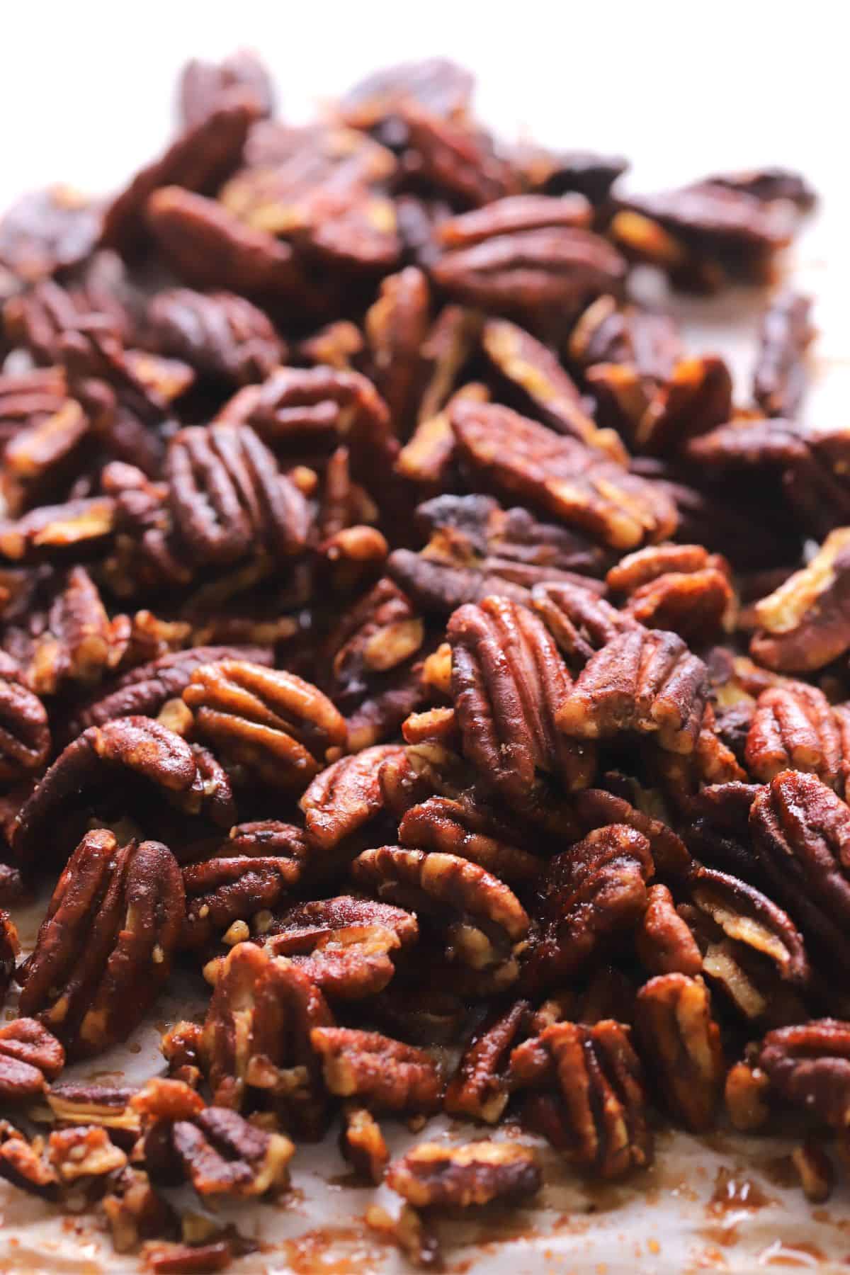 A pile of low carb candied pecans on a baking sheet.