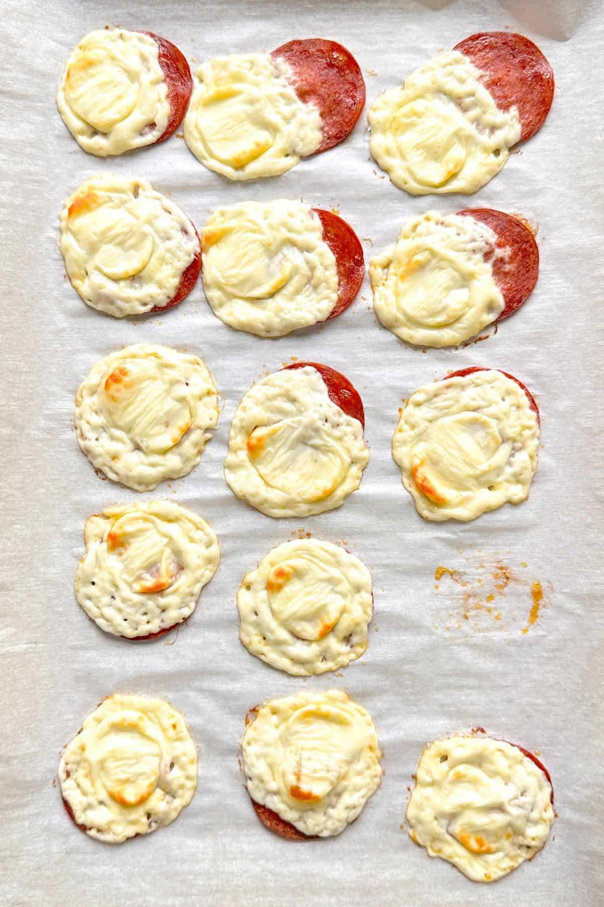 Baked ow carb pepperoni bites on parchment lined baking tray.