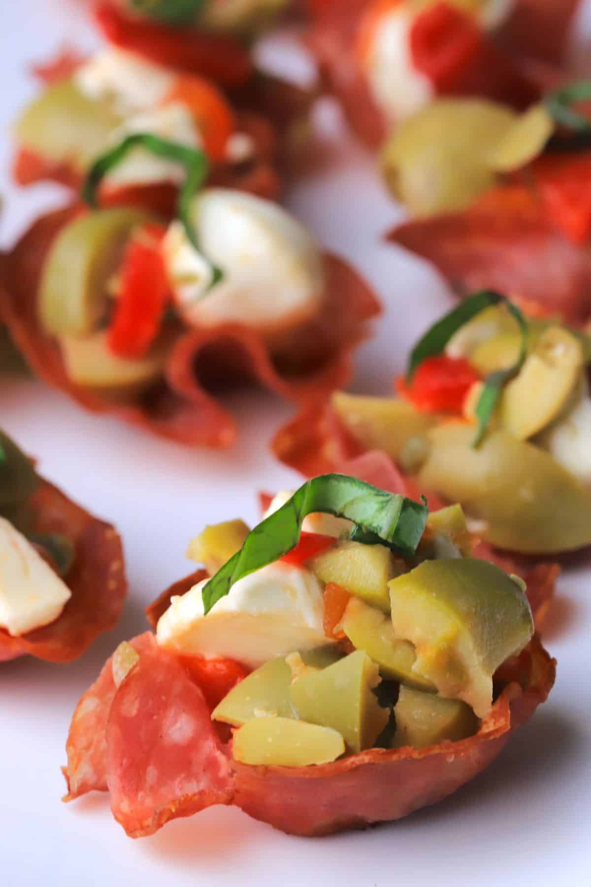 Salami cups on a white platter.