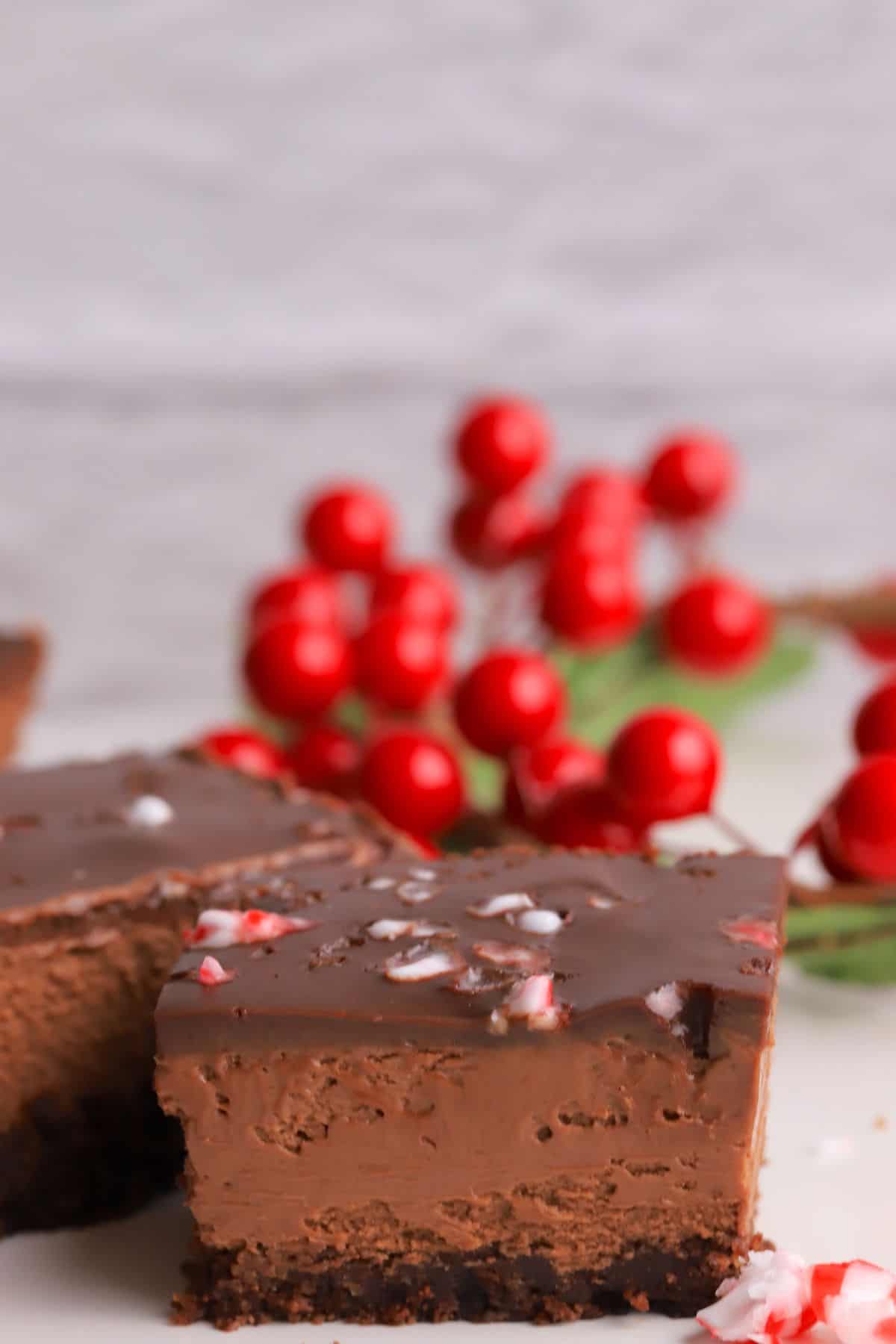 Squares of the sugar free peppermint mocha cheesecake bars with a missle toe in the background.