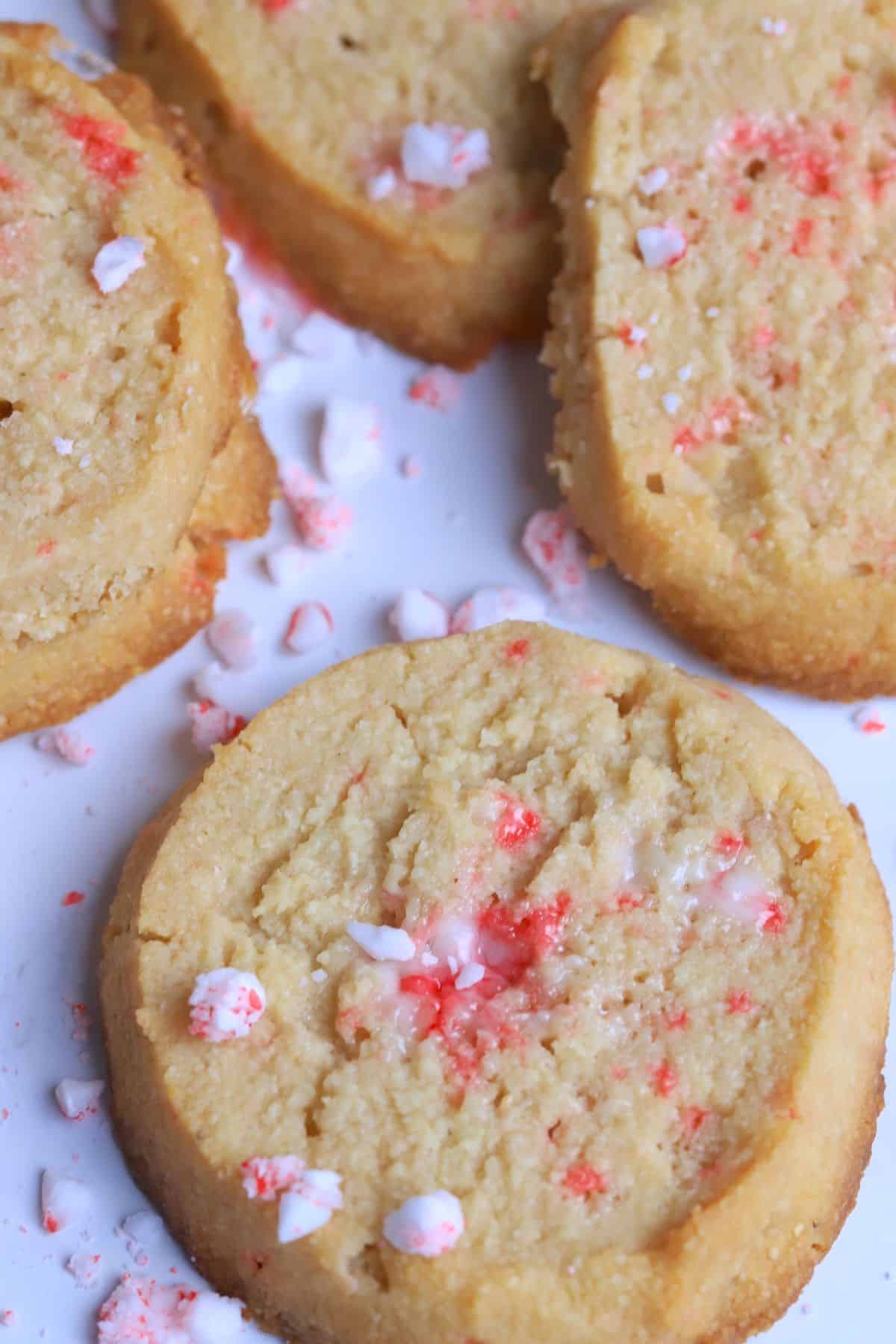 Sugar free peppermint shortbread cookies topped with crushed candy canes on a white plate.