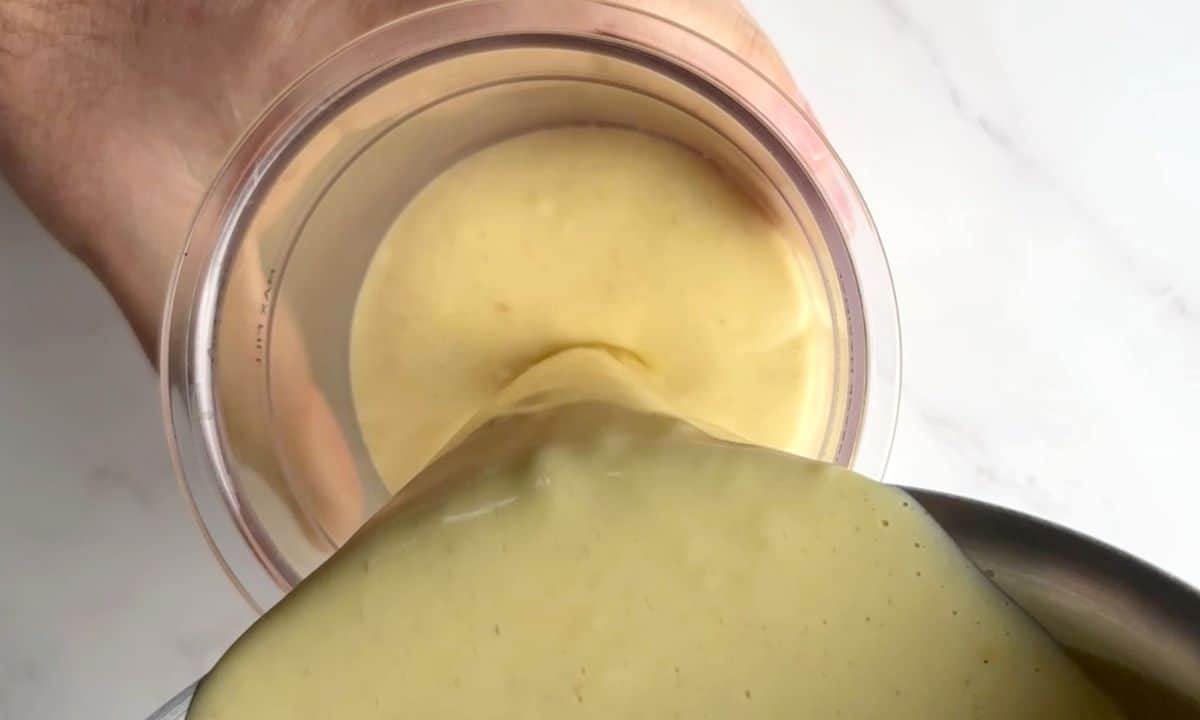 Pouring the eggnog mixture into the ninja creami pint.