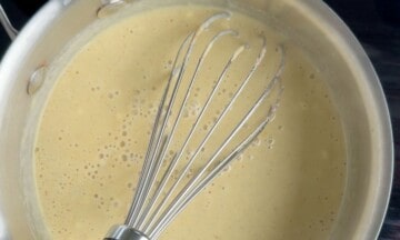 Whisking the eggnog mixture in a suacepan.