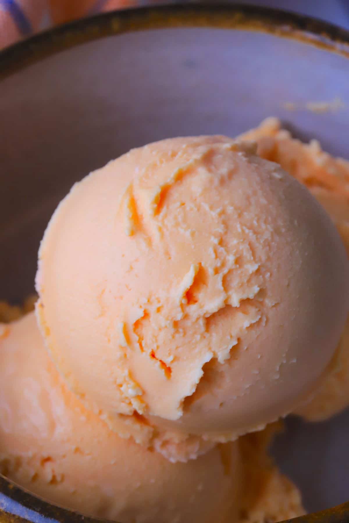 Close up of a scoop of sugar free orange creamsicle ice cream.