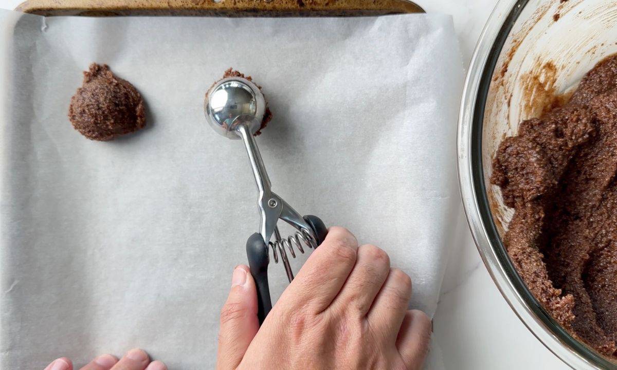 Scooping the batter into balls on a parchment lined baking sheet.