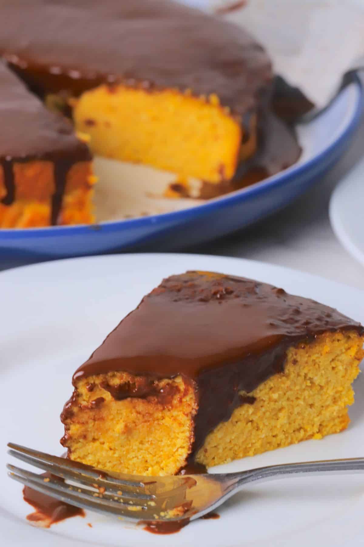 A slice of gluten free brazilian carrot cake with a fork on a plate.