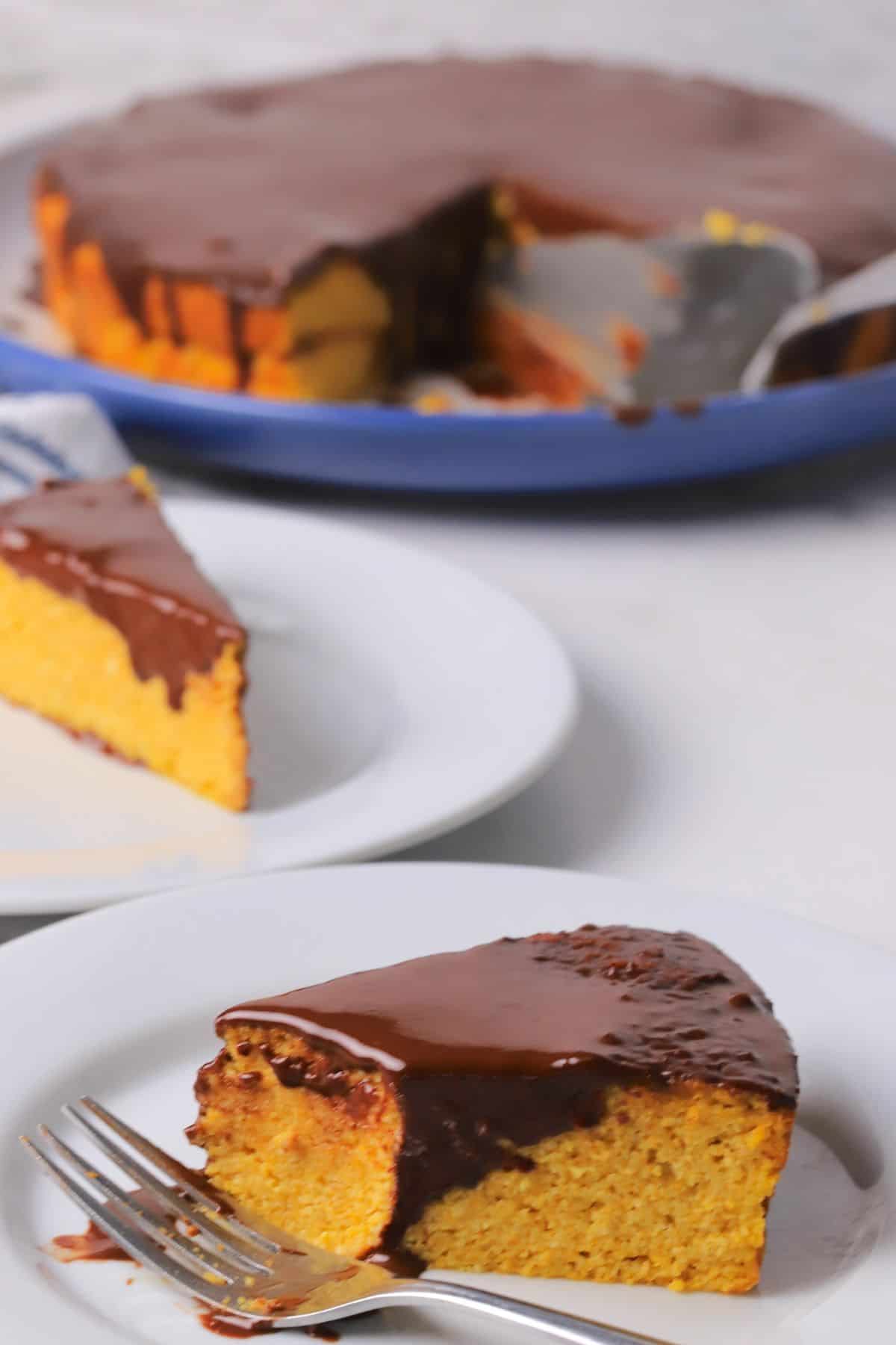 A slice of low carb brazilian carrot cake on a plate with another one behind it.