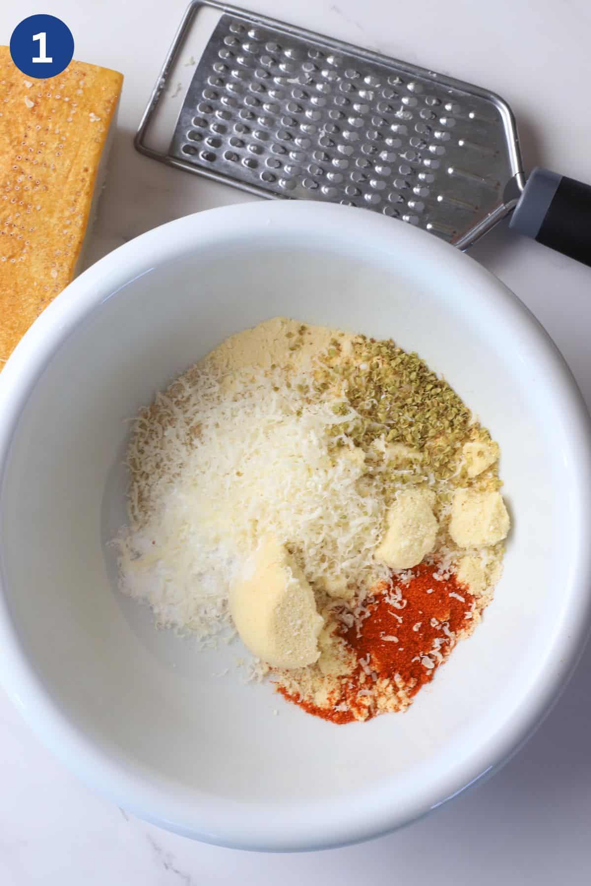 Mixture of breading seasoning in a bowl next to a shredder.