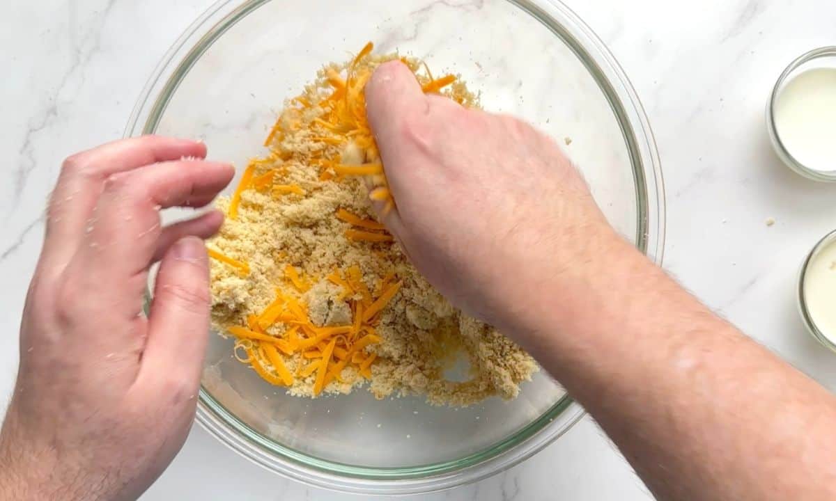 Hands in a bowl mixing the scone ingredients.