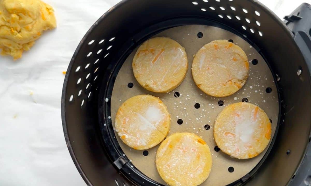 Uncooked scones in the air fryer basket brushed with milk.