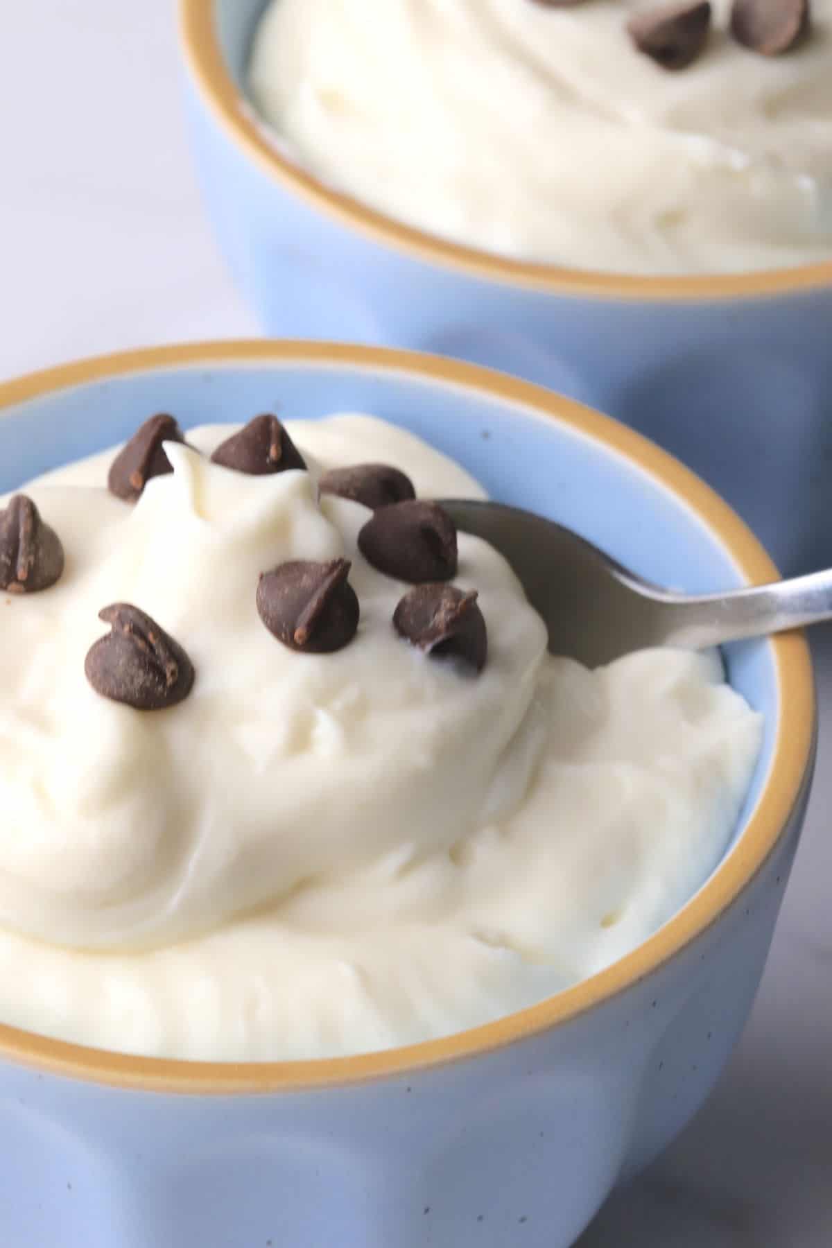 White chocolate mousse in blue bowls topped with sugar free chocolate chips.