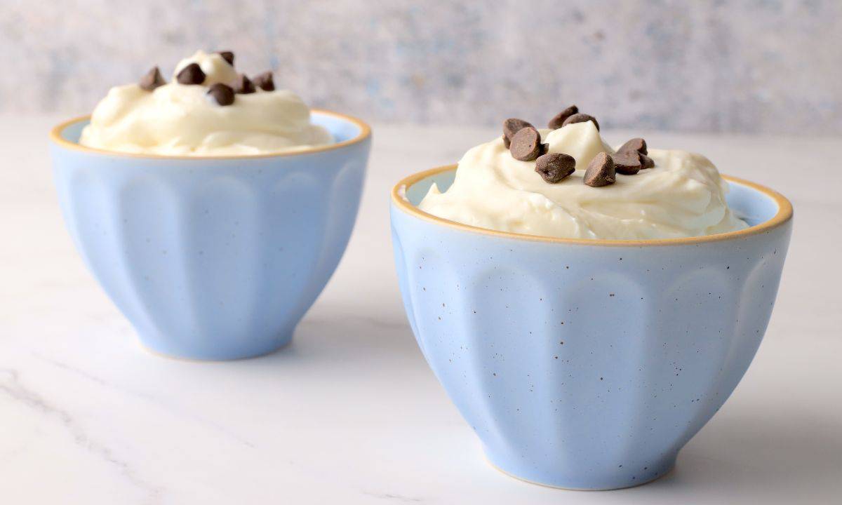 White chocolate mousse in blue bowls topped with sugar free chocolate chips.