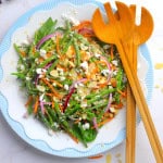 Low carb green bean salad on a plate with wooden tongs.