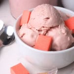 Sugar free bubble gum ice cream in a white bowl adorned with bubble gum pieces.