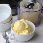 Sugar free pineapple ice cream in a white bowl next to the ninja creami pint.