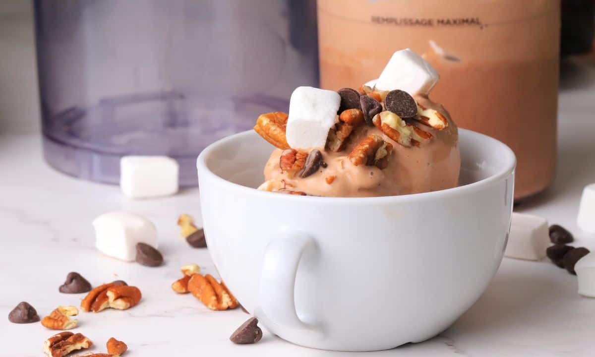 Sugar free rocky road ice cream in a bowl next to the ninja creami pint.