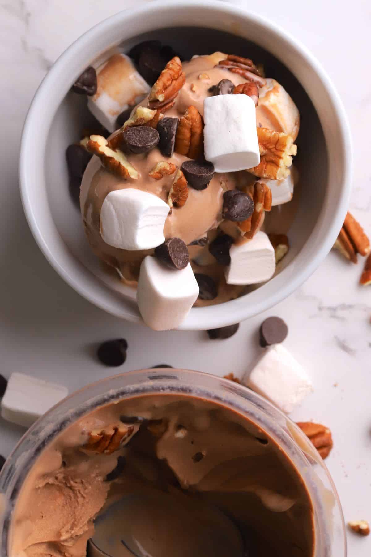 Sugar free rocky road ice cream in a bowl next to the ninja creami pint.
