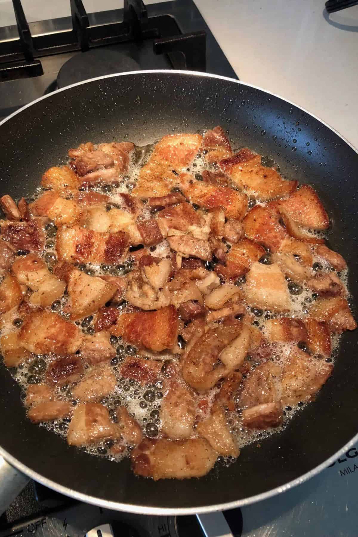 Sweet and spicy keto pork belly in a frying pan.