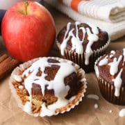 Low Carb Apple Cinnamon Muffins with a creamy sugar glaze next to an apple.