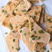 Broken pieces of the Sugar-Free Maple Pumpkin Yogurt Bark on a parchment paper.