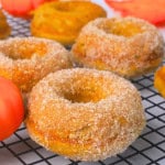 Sugar Free Pumpkin Spice Chai Donuts on a cooling rack next to a pumpkin ornament.