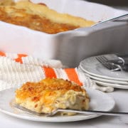 A portion of the low carb swiss chicken casserole on a plate with a fork and the casserole in the background.