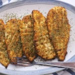 Low carb italian chicken cutlets on a plate with a fork.