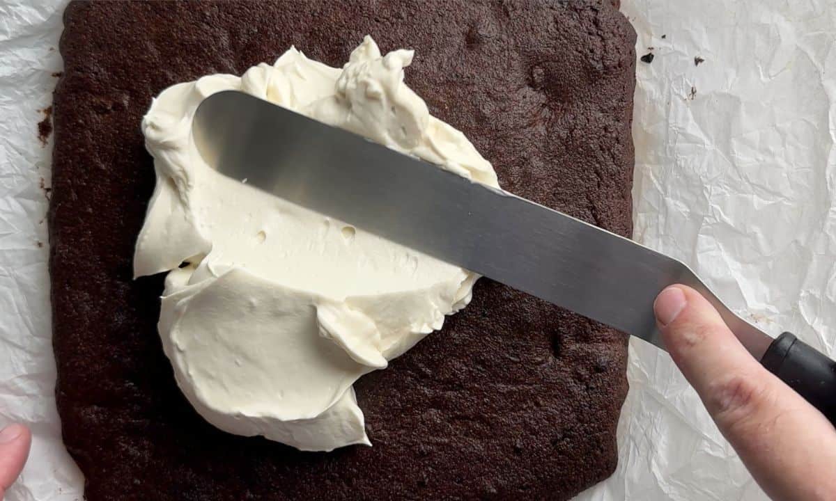 Spreading the frosting on top of the cake.