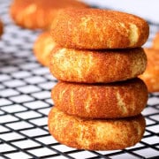 Low carb sugar free snickerdoodle cookies stacked on top of each other with other cookies behind it.