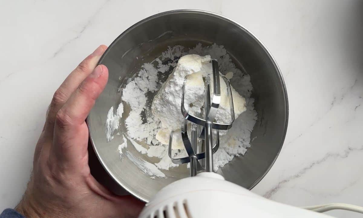 Beating the frosting in a bowl.