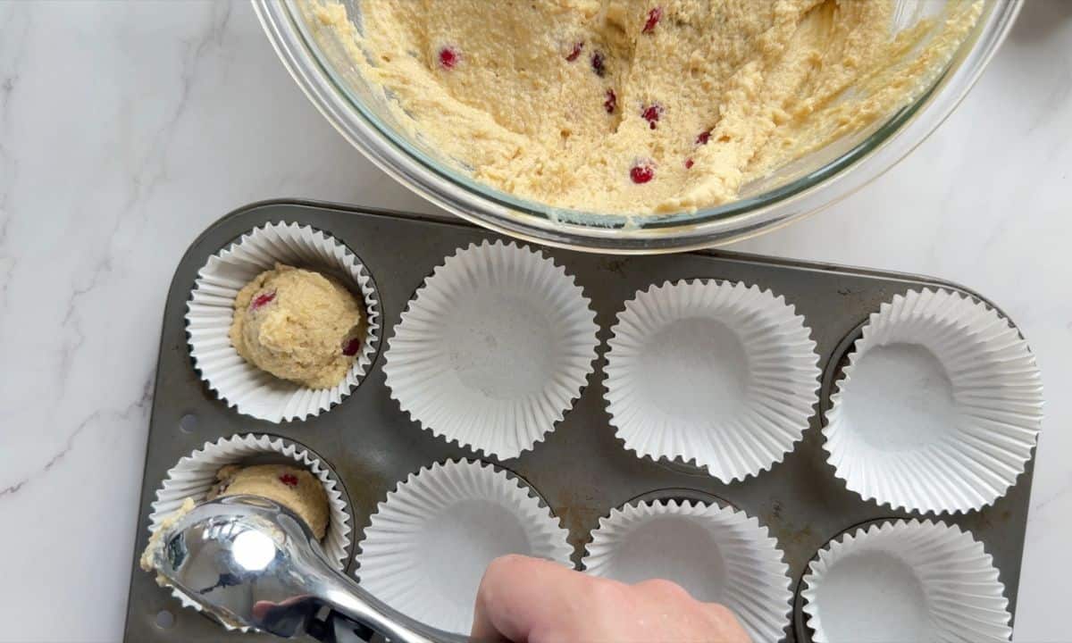 Scooping the muffin batter into the muffin liners.