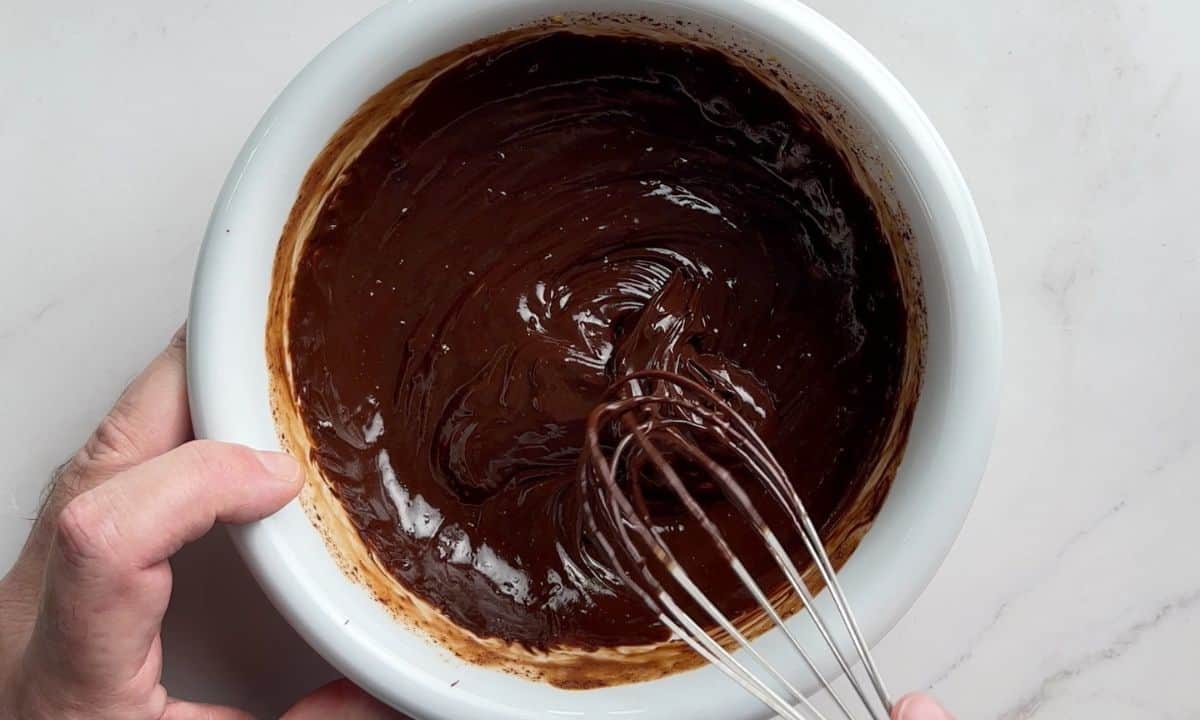 Whisking the chocolate in a white bowl.
