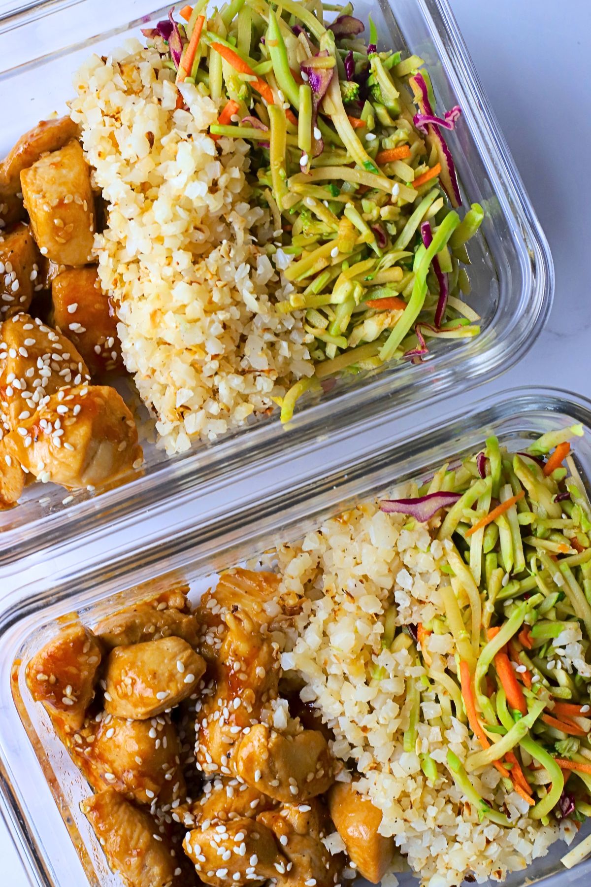 Low carb sesame chicken with cauliflower rice and asian coleslaw in glass tupperware containers.