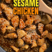 Sesame chicken in the skillet with a wooden spoon.