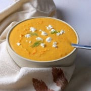 Soup bowl with tomato soup, topped with feta cheese and dill.