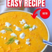 Soup bowl with tomato soup, topped with feta cheese and dill.