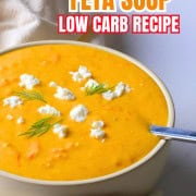Soup bowl with tomato soup, topped with feta cheese and dill.