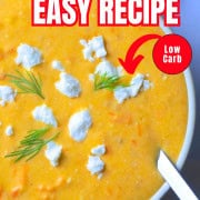 Soup bowl with tomato soup, topped with feta cheese and dill.