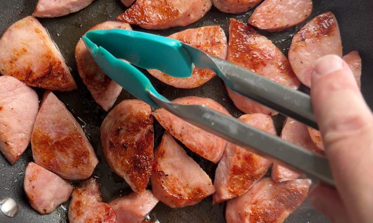 Frying the kielbasa sausage in the skillet.