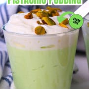High protein pistachio pudding in a glass cup topped with whipped cream and crushed pistachios.