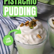 High protein pistachio pudding in a glass cup topped with whipped cream and crushed pistachios.