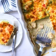 A slice of low carb italian chicken veggie casserole on a plate with the casserole dish next to it.