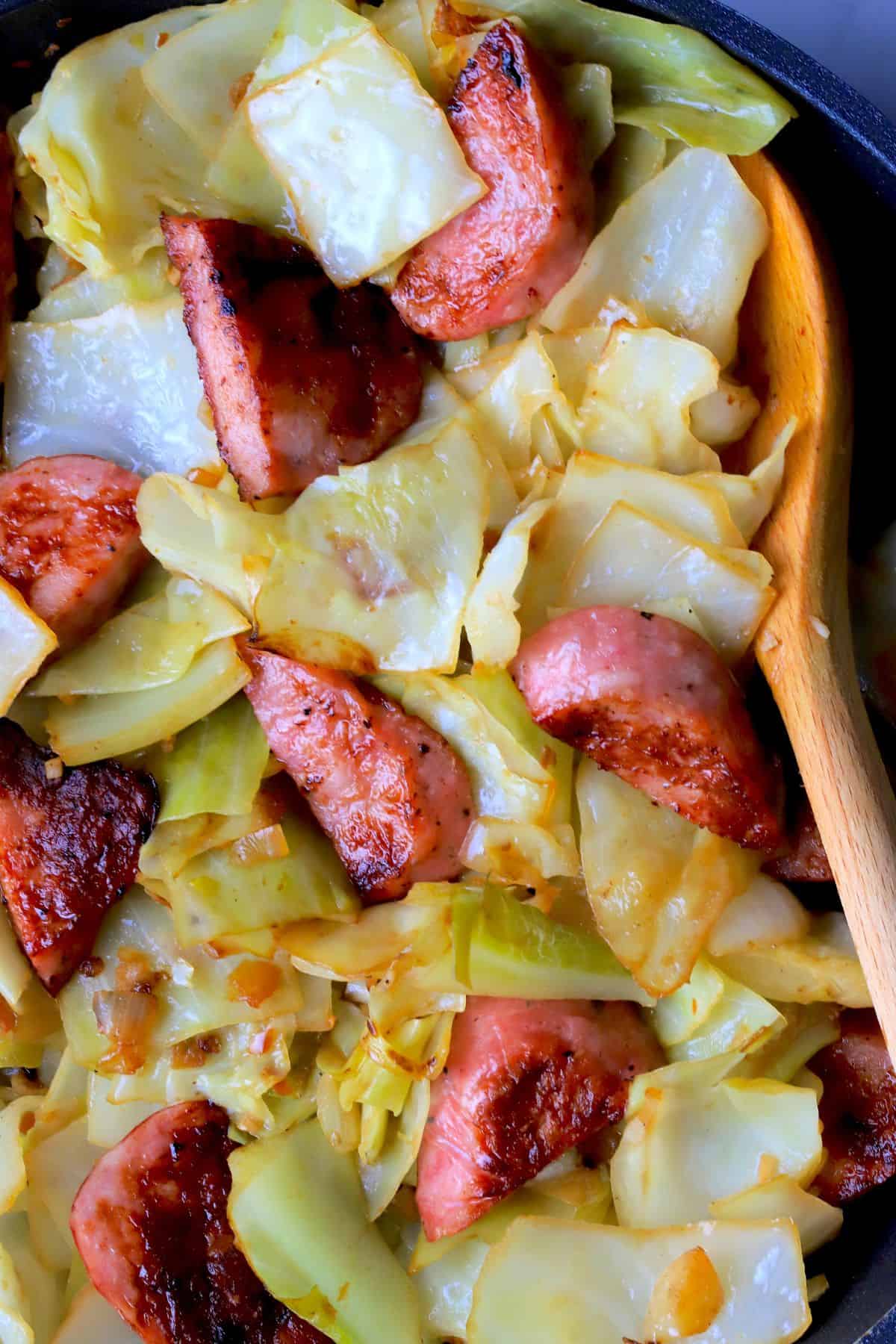 Cabbage and sausage in a skillet.