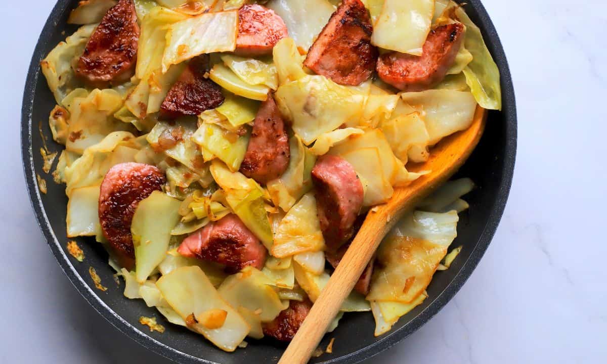 Cabbage and sausage in a skillet.