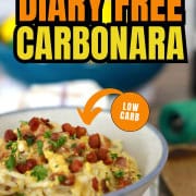 Bowl of dairy free spaghetti carbonara topped with pancetta and chopped parsley.