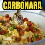 Bowl of dairy free spaghetti carbonara topped with pancetta and chopped parsley.